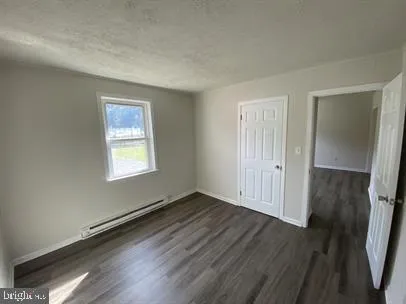 an empty room with wooden floor and a window