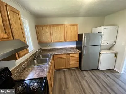 a kitchen with a refrigerator a stove and wooden cabinets