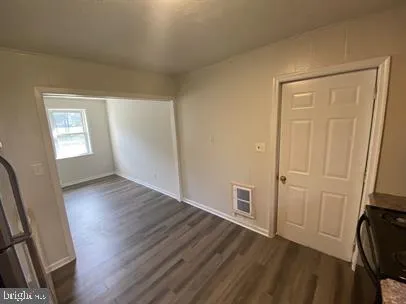 an empty room with wooden floor and a window