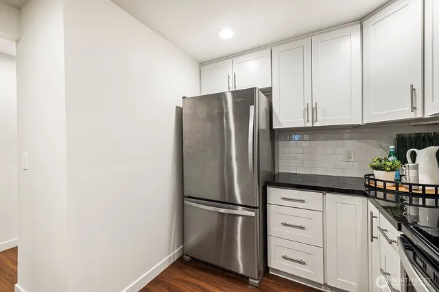 a kitchen with stainless steel appliances white cabinets and a refrigerator