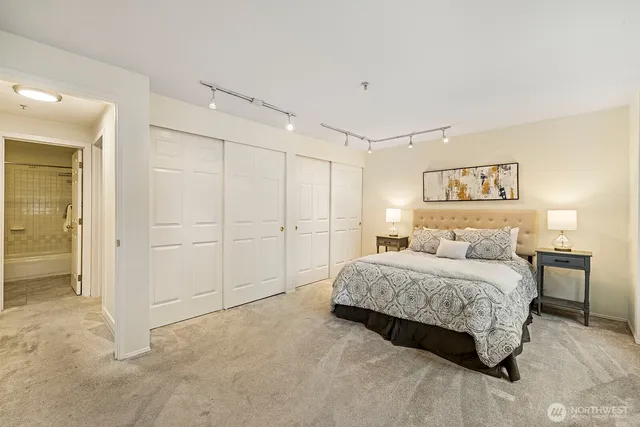 a spacious bedroom with a bed and a lamp