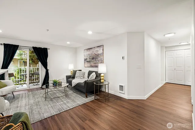 a living room with furniture wooden floor and large window