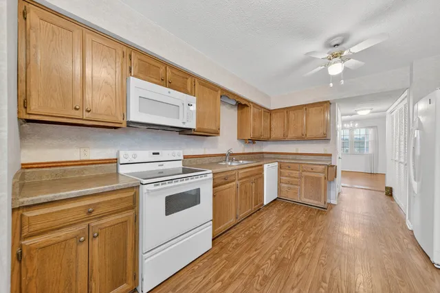 a view of an empty room with wooden floor and a fireplace