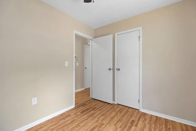 a view of an empty room with wooden floor