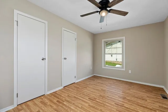 a view of empty room with window and ceiling fan