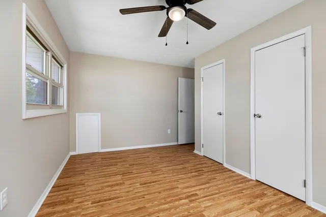 a view of empty room with wooden floor