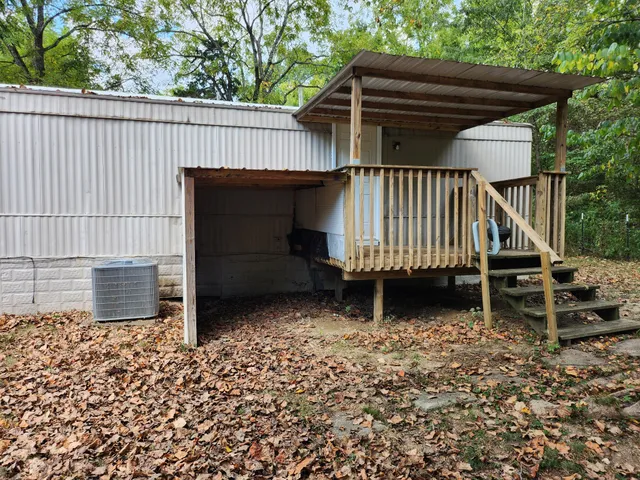 a view of wooden house with a small yard and wooden fence