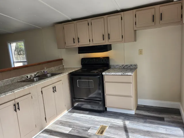 a kitchen with granite countertop white cabinets and white appliances