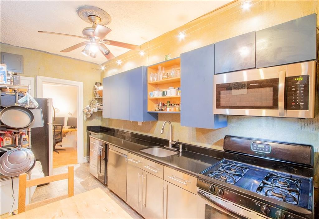 7901 4th Avenue, Unit C21 Brooklyn, NY 11209 - Photo 4 of 21 a kitchen with a stove a sink and a wooden cabinets