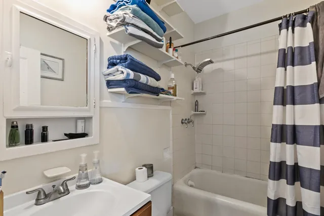 a living room with furniture kitchen view and a potted plant