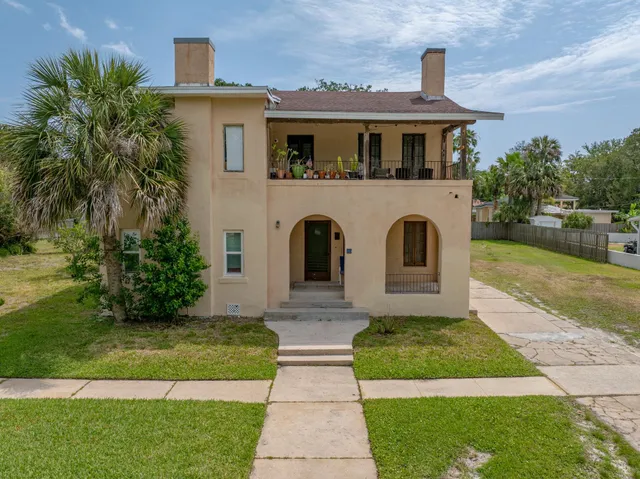 a view of a balcony with chairs and wooden fence
