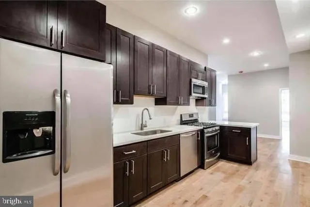 a kitchen with stainless steel appliances granite countertop a sink stove and refrigerator
