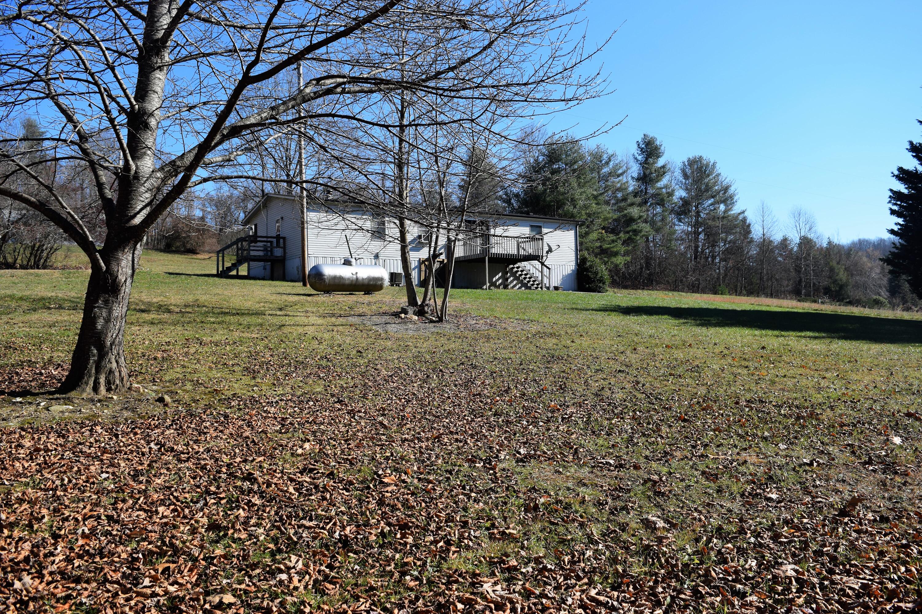 7547 Conner Road Northeast Copper Hill, VA 24079 - Photo 5 of 27 a yellow house with a trees in front of it