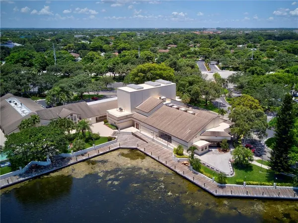 an aerial view of a house with a garden and lake view