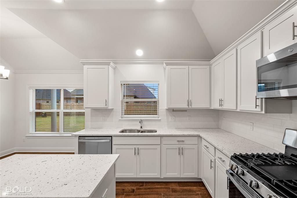 304 Prien Lk Loop Bossier City, LA 71111 - Photo 19 of 39 Modern kitchen featuring white cabinetry, light-colored speckled countertops, and a white subway tile backsplash