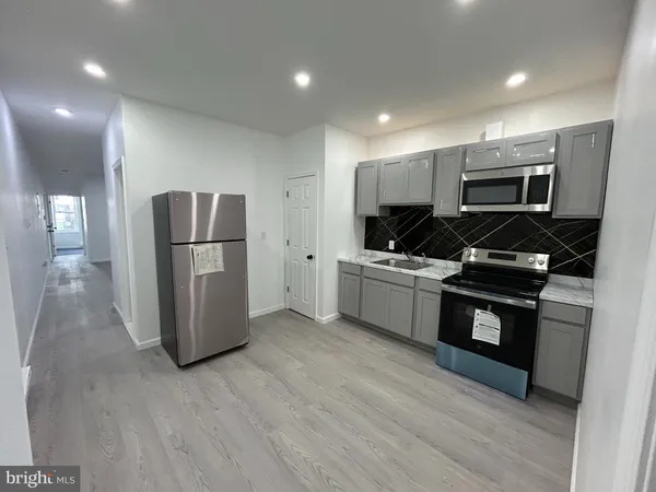 a kitchen with a refrigerator and a stove top oven