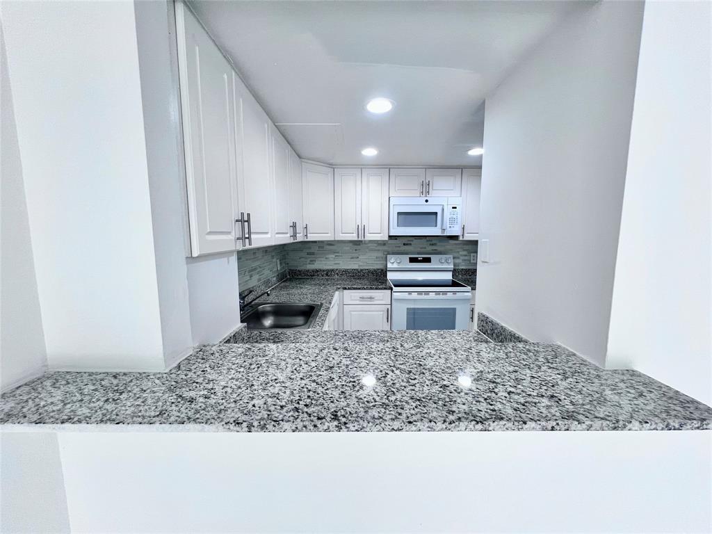 2580 Northwest 56th Avenue, Unit 600404 Lauderhill, FL 33313 - Photo 2 of 17 a kitchen with stainless steel appliances granite countertop a sink stove and refrigerator