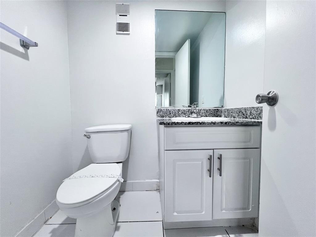 2580 Northwest 56th Avenue, Unit 600404 Lauderhill, FL 33313 - Photo 7 of 17 a bathroom with a toilet a sink and mirror