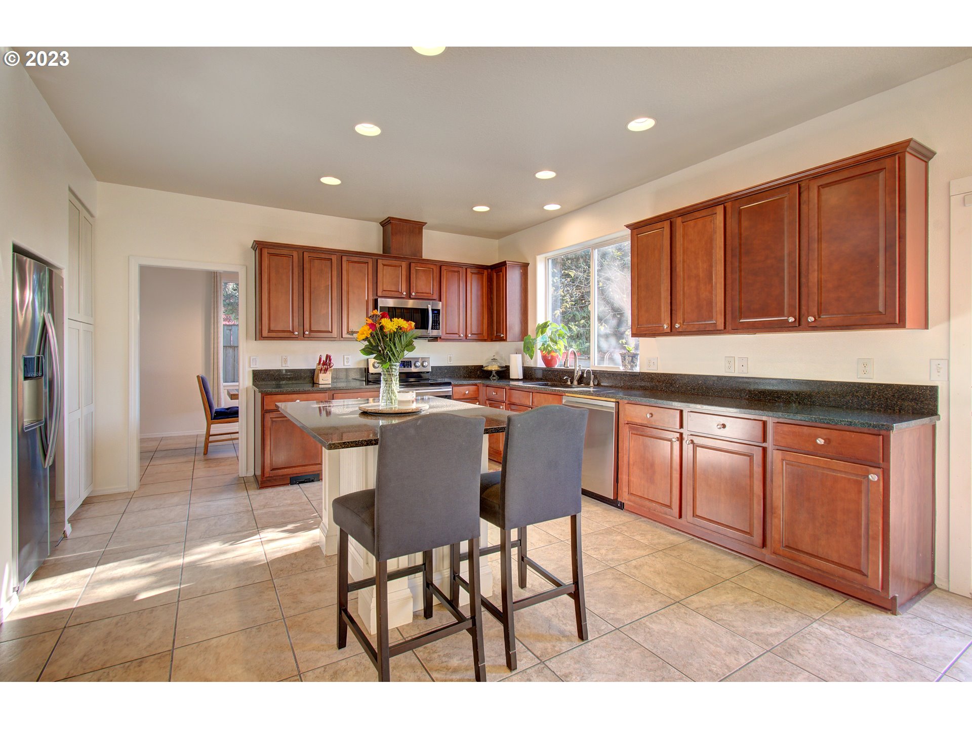4762 Southeast 20th Terrace Gresham, OR 97080 - Photo 7 of 34 a kitchen with granite countertop a table chairs microwave and cabinets