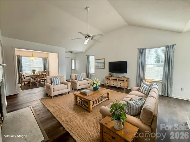 a living room with furniture flat screen tv and a large window