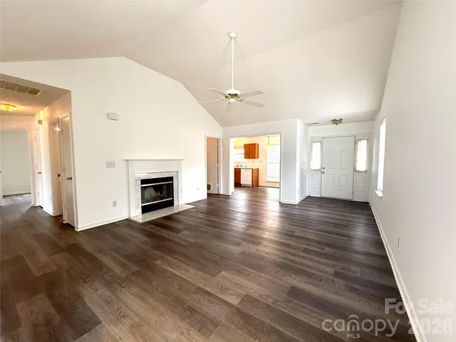 an empty room with wooden floor and fireplace
