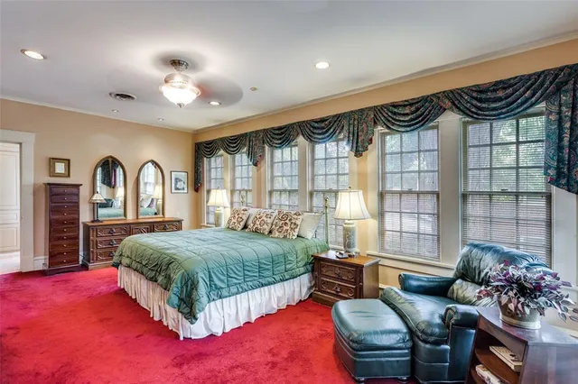 a spacious bedroom with a bed and a large window