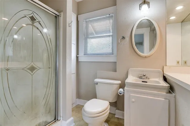 a bathroom with a toilet a sink and a mirror