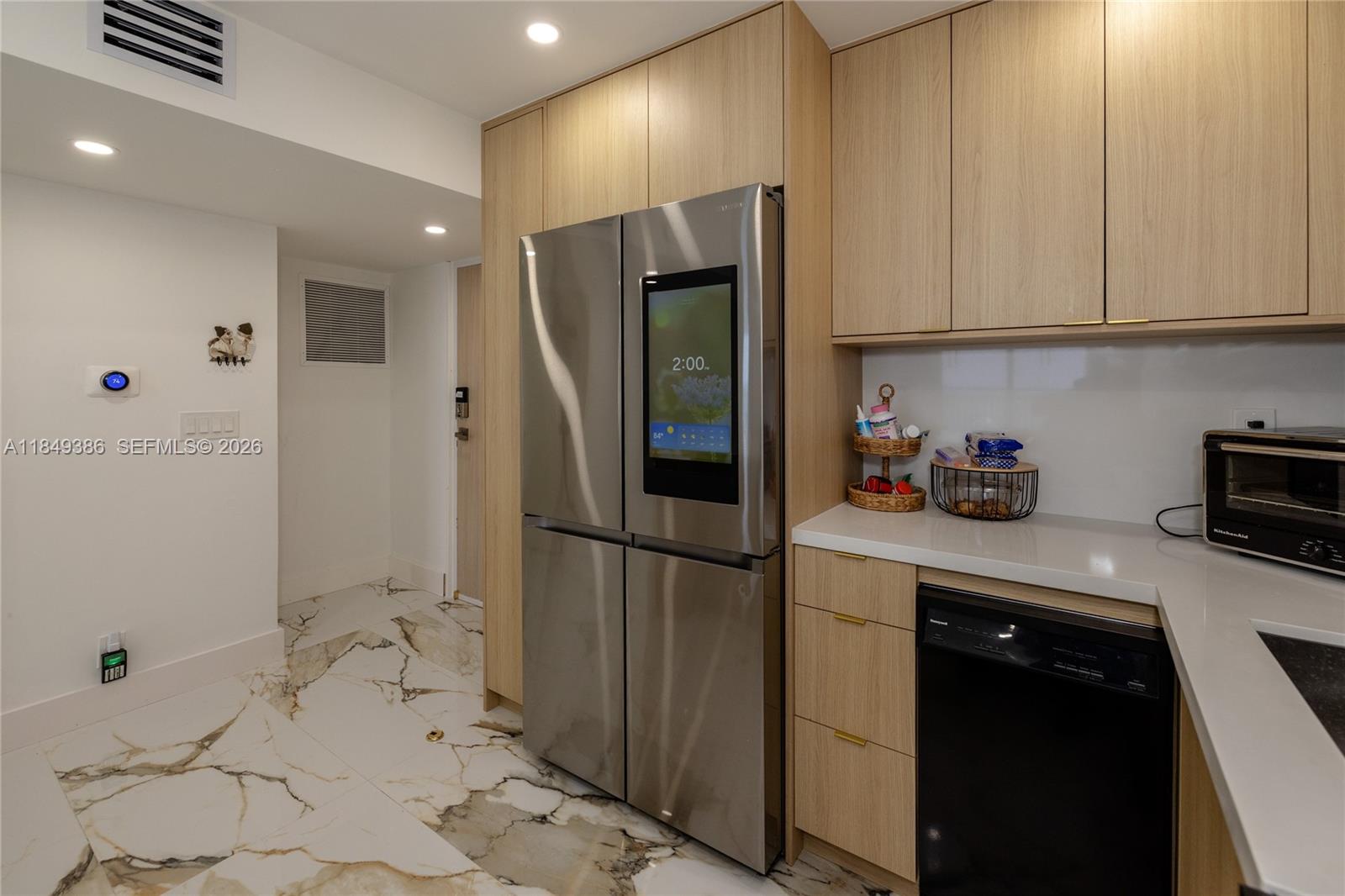 400 North Surf Road, Unit 1002 Hollywood, FL 33019 - Photo 11 of 43 a kitchen with a refrigerator and cabinets