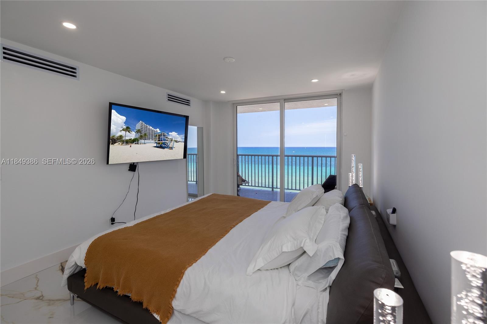 400 North Surf Road, Unit 1002 Hollywood, FL 33019 - Photo 18 of 43 a bedroom with a bed and a flat screen tv