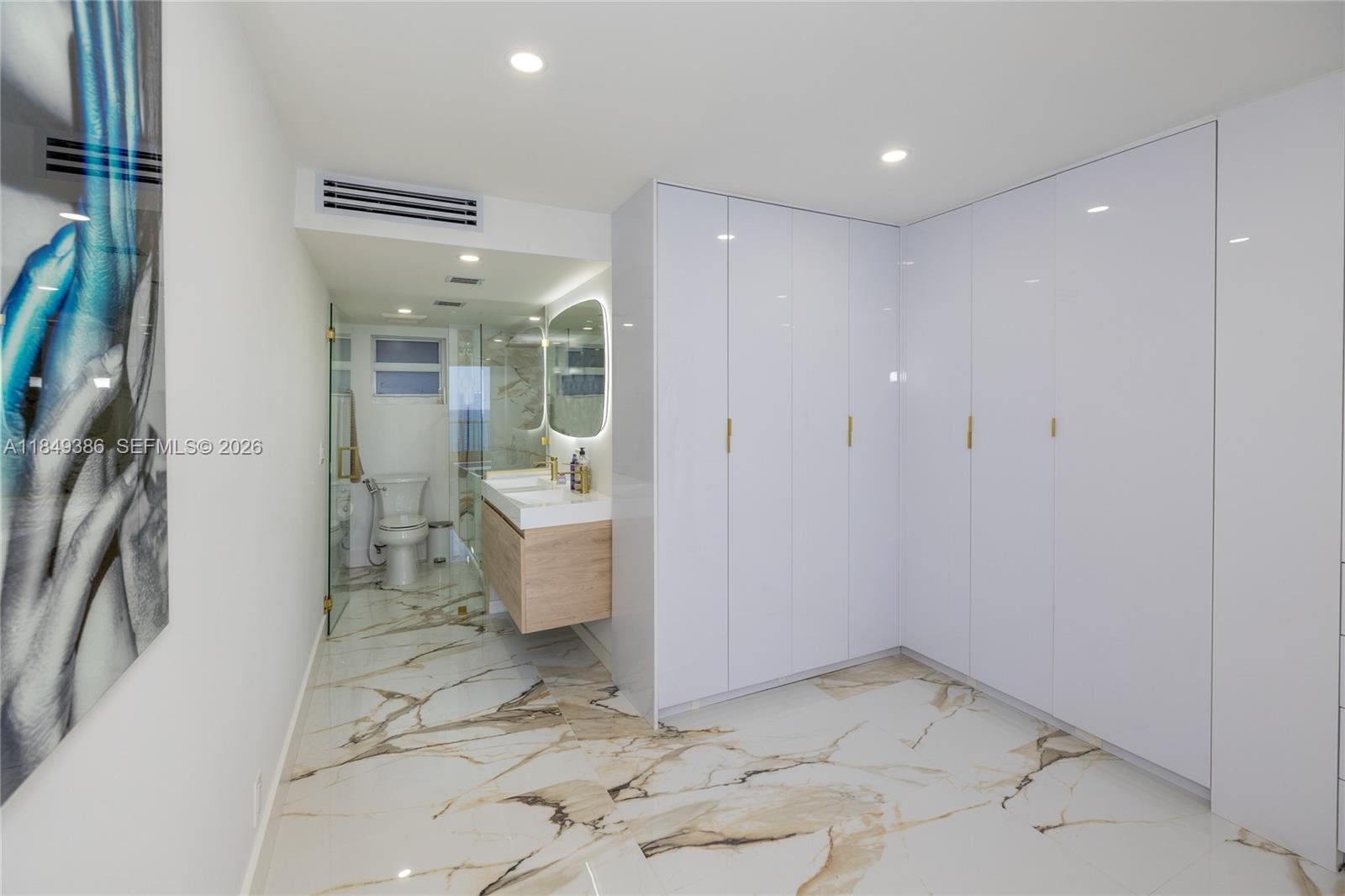 400 North Surf Road, Unit 1002 Hollywood, FL 33019 - Photo 6 of 43 a bathroom with a sink and glass door shower