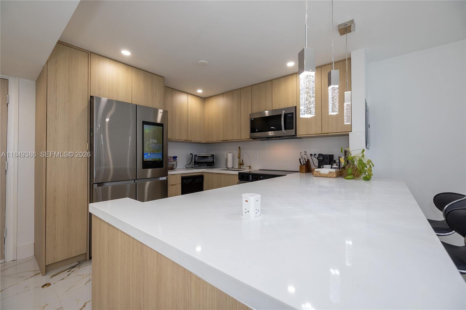 400 North Surf Road, Unit 1002 Hollywood, FL 33019 - Photo 7 of 43 a kitchen with stainless steel appliances a refrigerator sink a microwave a stove and a refrigerator with wooden floor