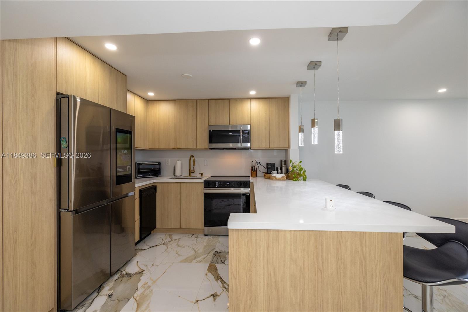400 North Surf Road, Unit 1002 Hollywood, FL 33019 - Photo 8 of 43 a kitchen with a refrigerator and a stove top oven