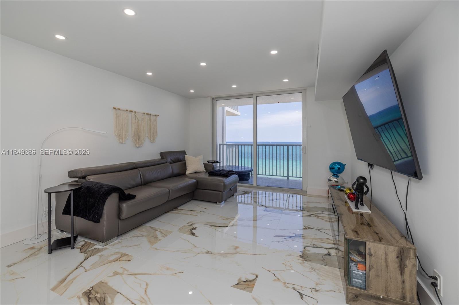 400 North Surf Road, Unit 1002 Hollywood, FL 33019 - Photo 9 of 43 a living room with furniture a flat screen tv and a table