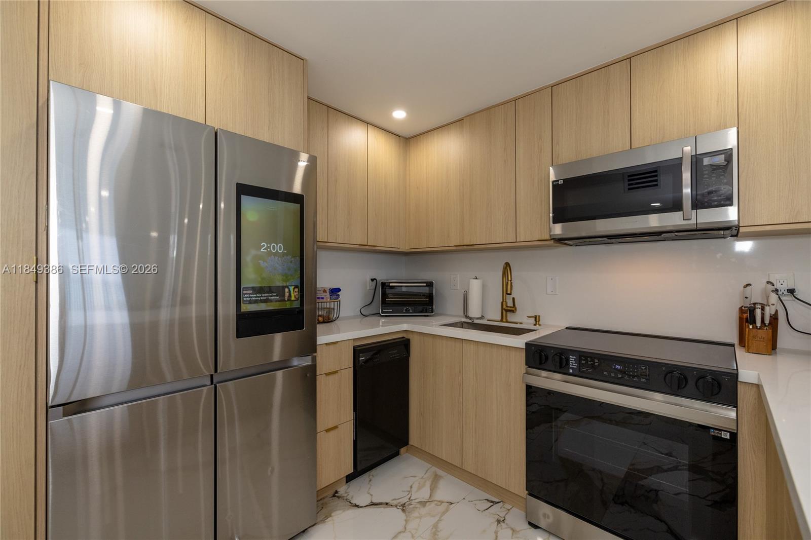 400 North Surf Road, Unit 1002 Hollywood, FL 33019 - Photo 10 of 43 a kitchen with stainless steel appliances granite countertop a refrigerator sink and microwave