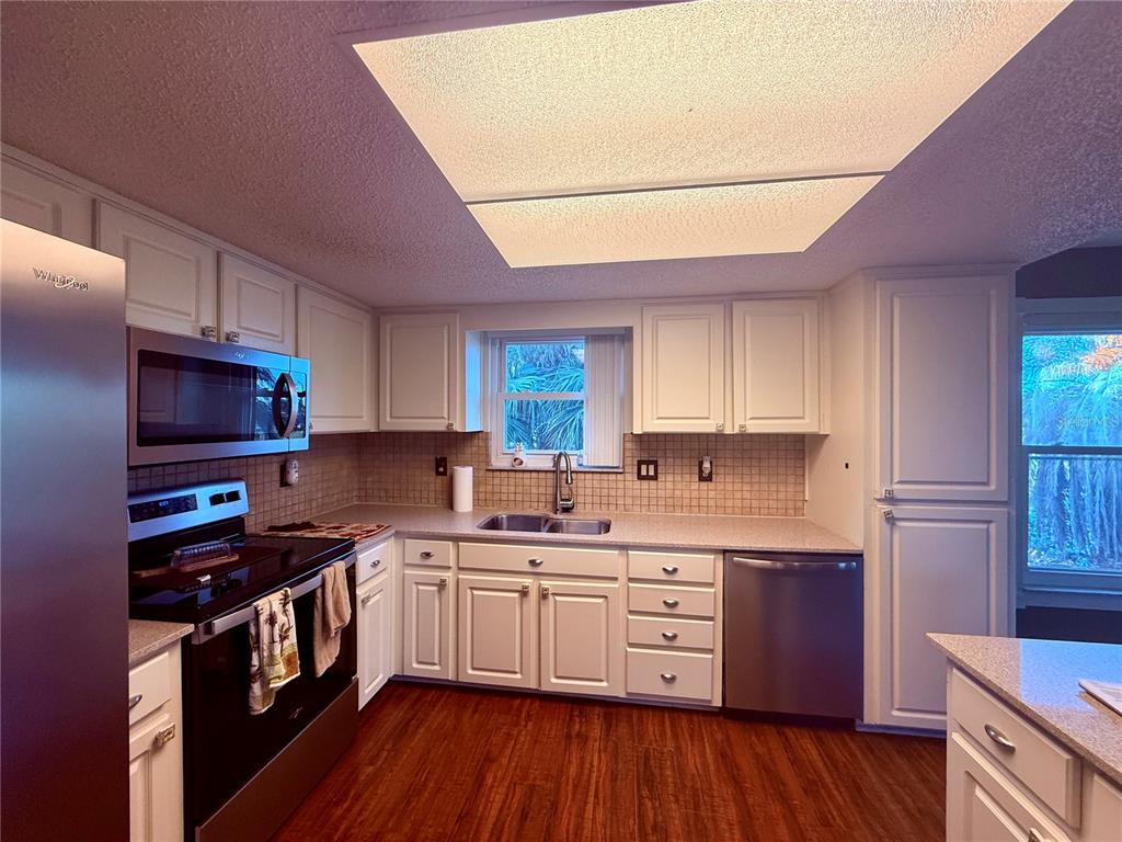 3338 Fernleaf Drive Hernando Beach, FL 34607 - Photo 15 of 69 a kitchen with stainless steel appliances a sink cabinets and wooden floor