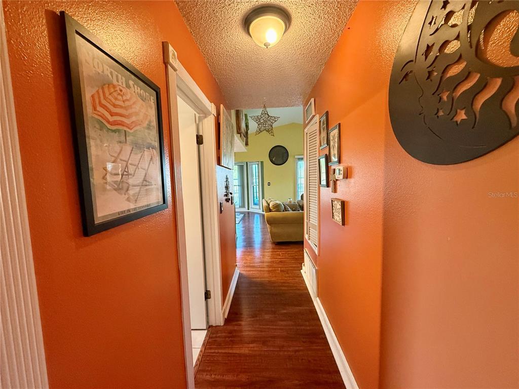 3338 Fernleaf Drive Hernando Beach, FL 34607 - Photo 32 of 69 a view of a hallway with wooden floor and a bathroom