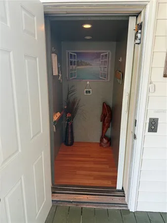 a room with wooden floors a sink stainless steel appliances and cabinets