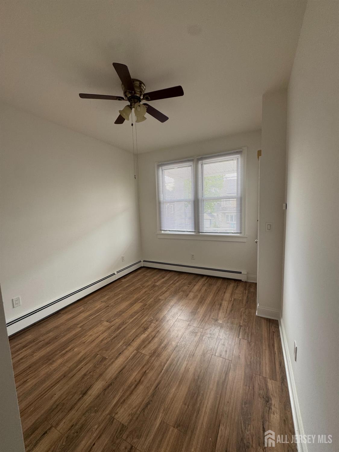 36 Paul Street, Unit 38 Fords, NJ 08863 - Photo 3 of 3 an empty room with wooden floor and windows