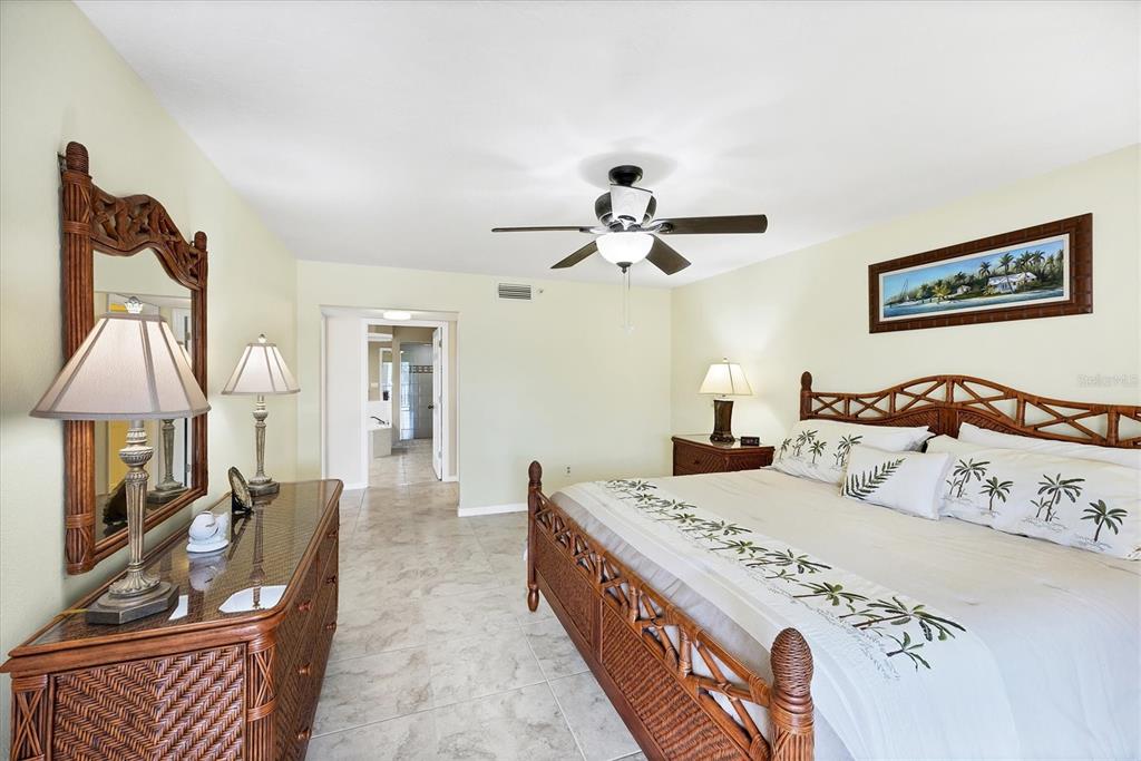 11000 Placida Road, Unit 2202 Placida, FL 33946 - Photo 22 of 58 a spacious bedroom with a bed a couch and a chandelier