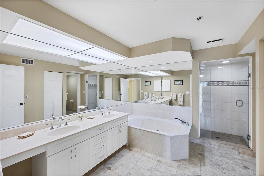 11000 Placida Road, Unit 2202 Placida, FL 33946 - Photo 23 of 58 a bathroom with a double vanity sink a large mirror and shower