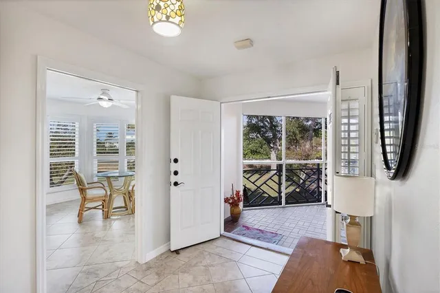 a kitchen with stainless steel appliances kitchen island granite countertop a refrigerator a stove a dining table and chairs with wooden floor