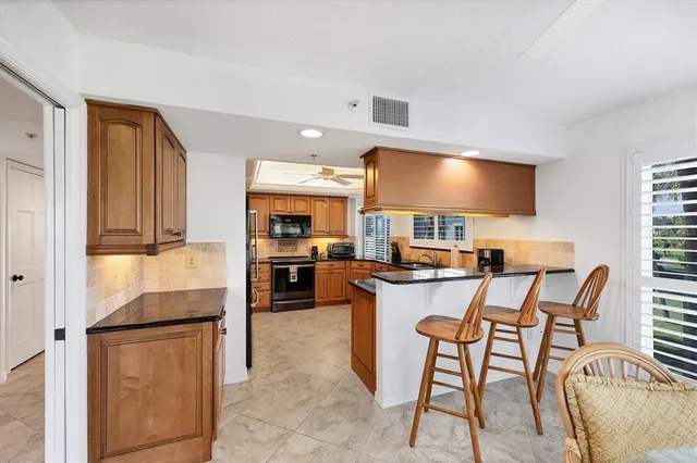 a kitchen with stainless steel appliances granite countertop a sink dishwasher stove and refrigerator