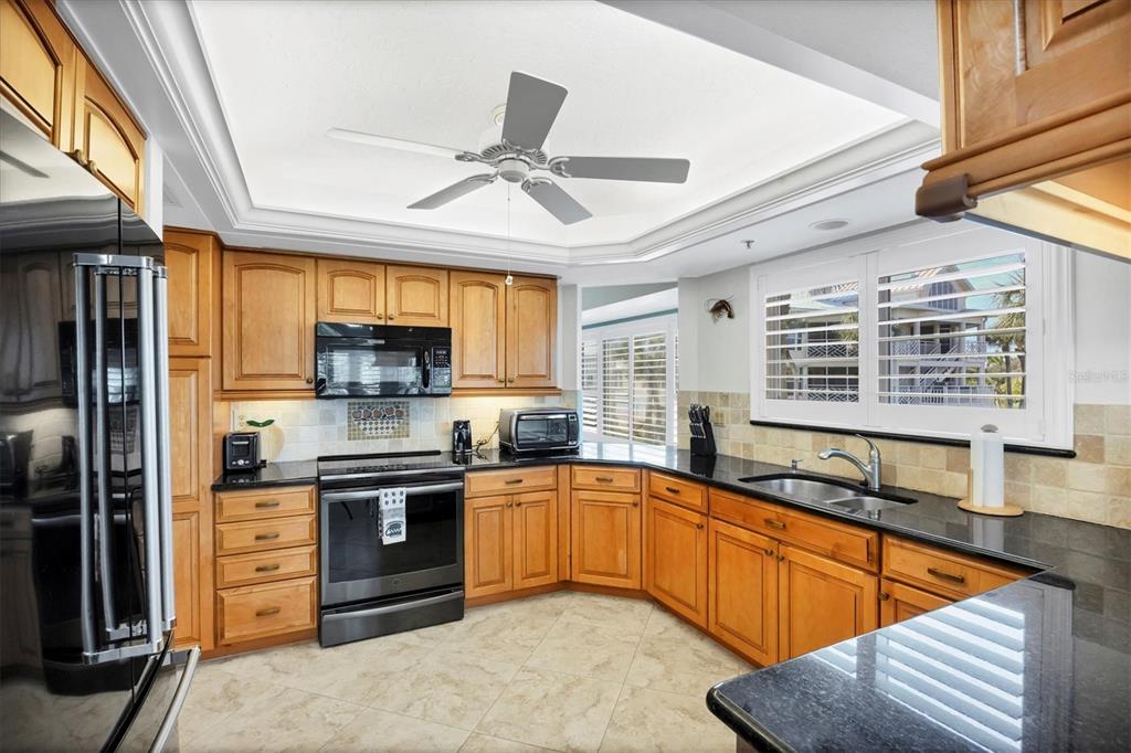 11000 Placida Road, Unit 2202 Placida, FL 33946 - Photo 6 of 58 a kitchen with stainless steel appliances granite countertop a sink stove and refrigerator