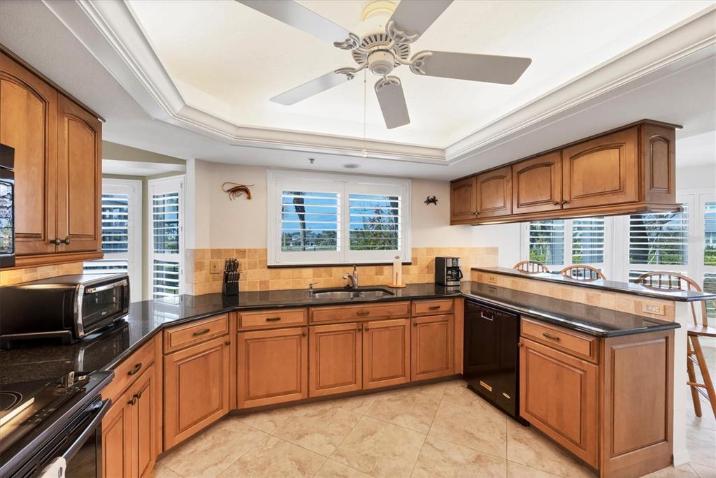11000 Placida Road, Unit 2202 Placida, FL 33946 - Photo 7 of 58 a kitchen with stainless steel appliances granite countertop a sink dishwasher stove and refrigerator