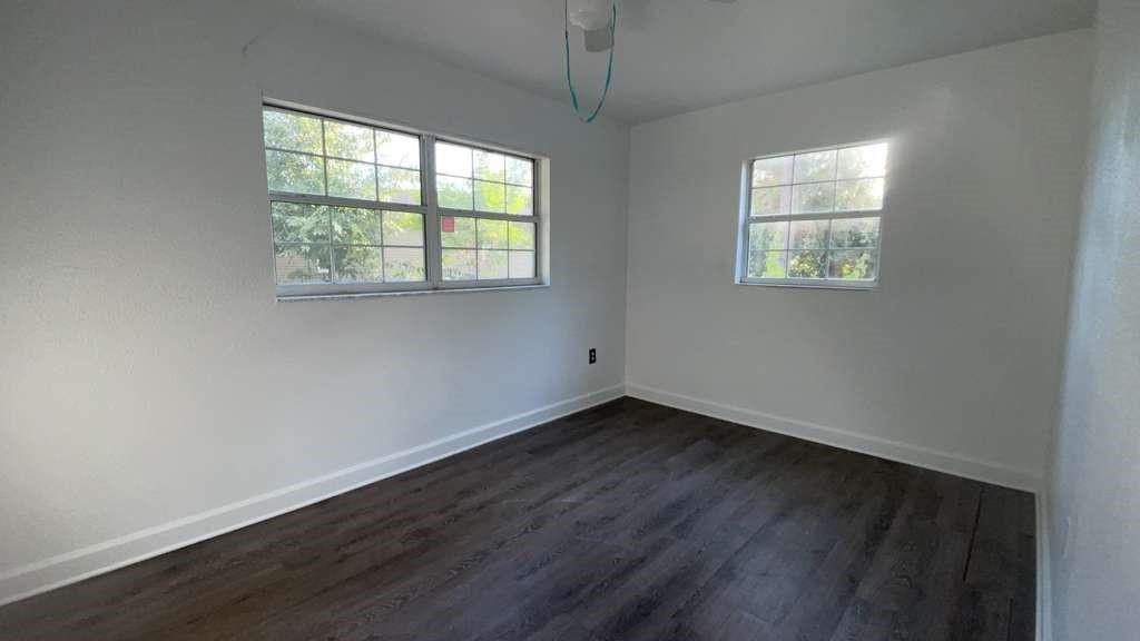 216 Maria Street Fort Myers, FL 33916 - Photo 5 of 19 an empty room with wooden floor and windows