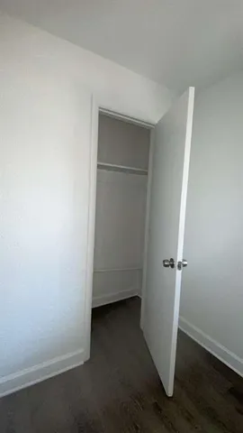 an empty room with wooden floor and closet