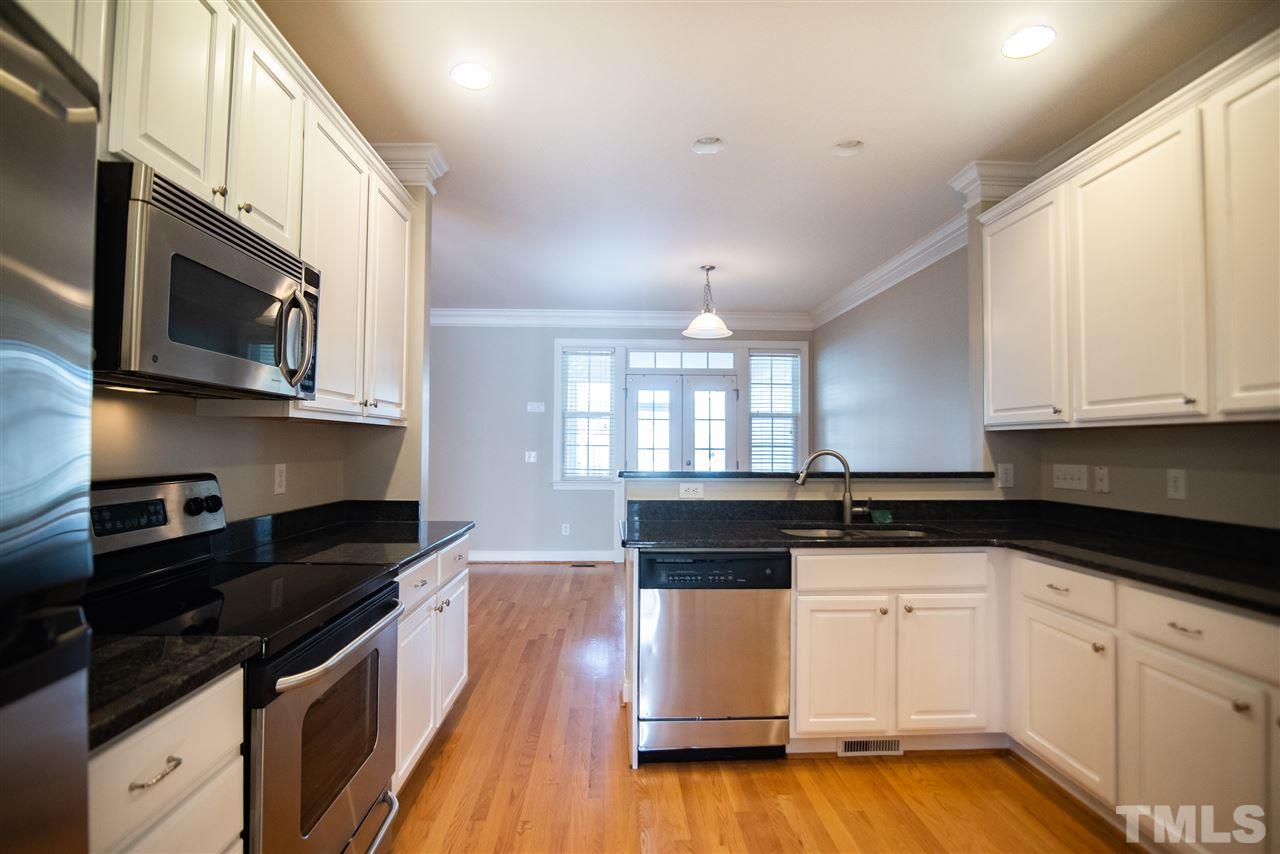 11006 Flower Bed Court Raleigh, NC 27614 - Photo 7 of 24 a kitchen with granite countertop white cabinets and black appliances