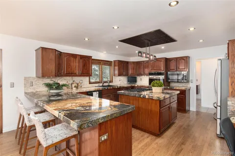 a kitchen with a stove a refrigerator and a dining table
