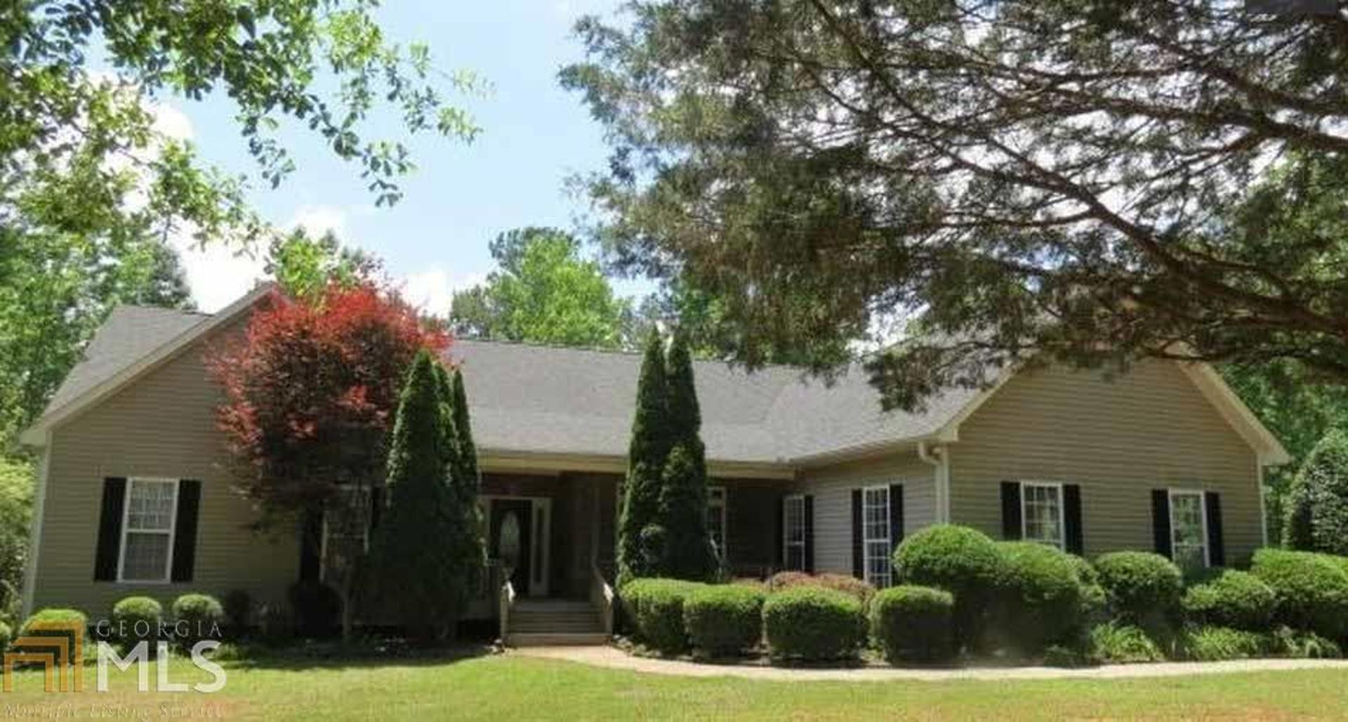 3844 Lower Tanners Bridge Road Monroe, GA 30656 - Photo 1 of 1 a front view of a house with a yard and a garage
