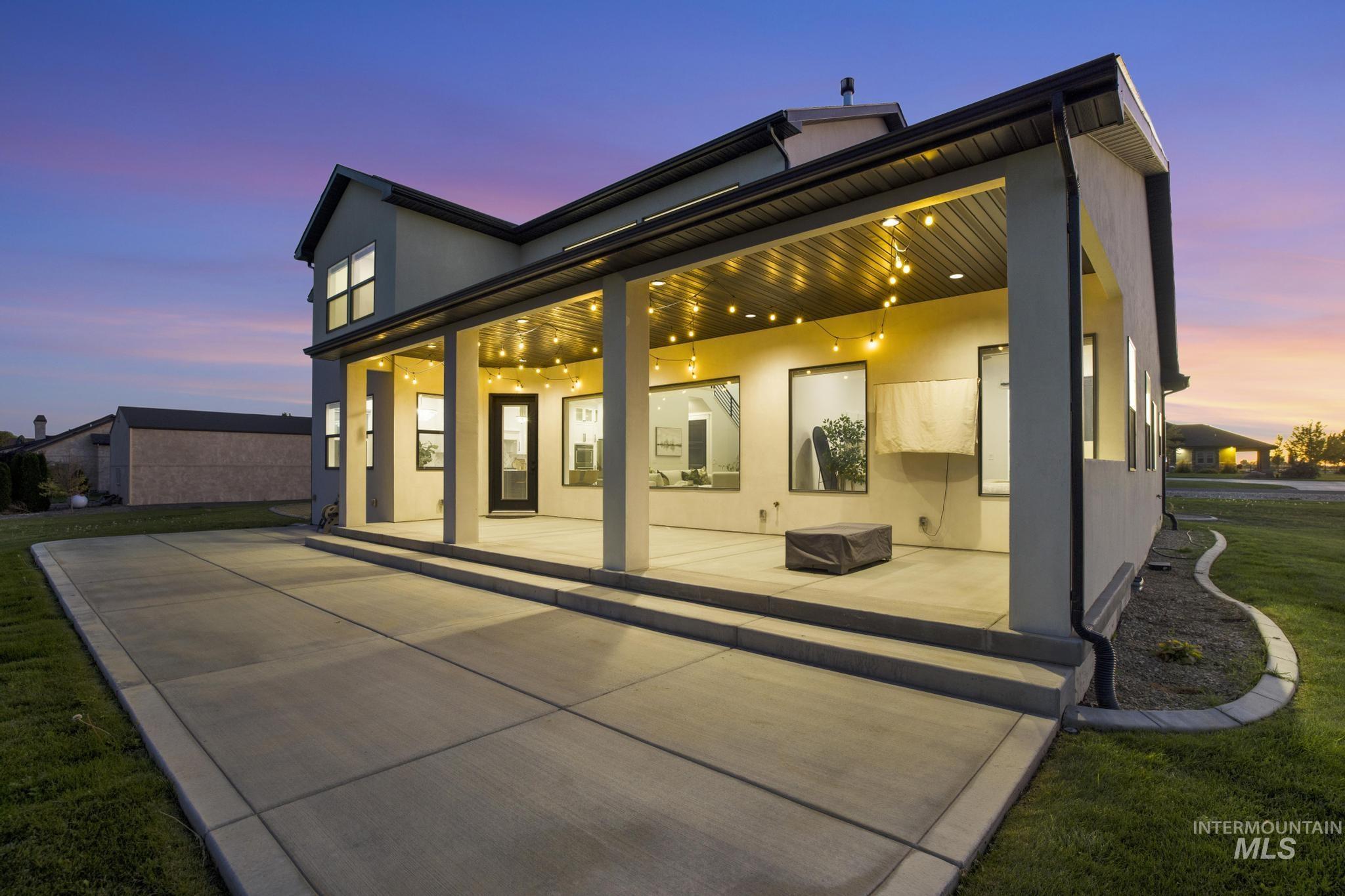 4280 Rim Vista Road Filer, ID 83328 - Photo 45 of 50 Expansive concrete patio with a covered outdoor living area, recessed lighting, multiple large windows, and a dark-framed glass door